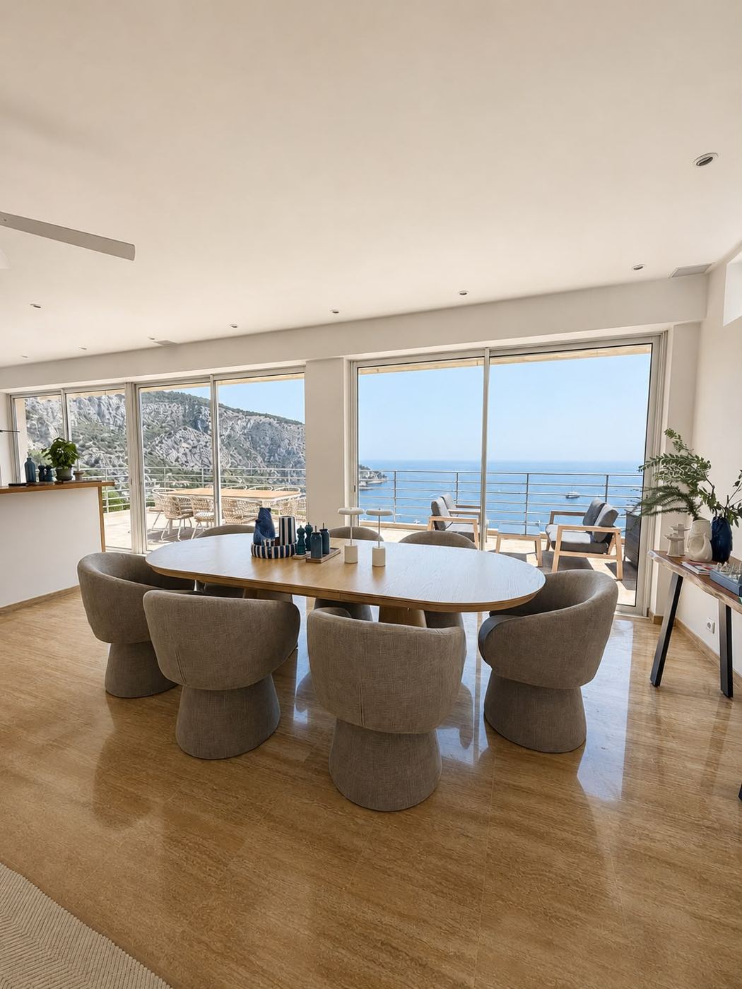 Salle à manger avec grandes baies vitrées face à la mer